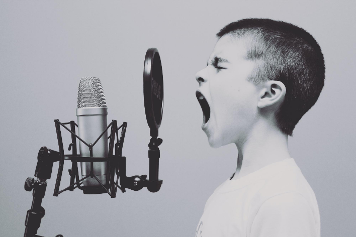 "Boy Singing on Microphone with Pop Filter" by Jason Rosewell on Unsplash.com
