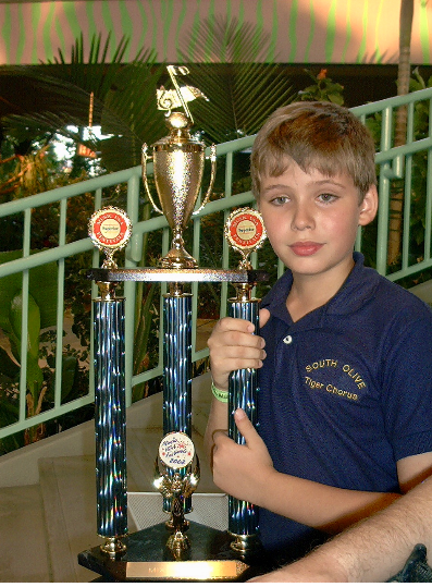 South Olive Elementary Tiger Chorus Member Holding a "Superior" Rating Trophy, InTuneWithYou.com